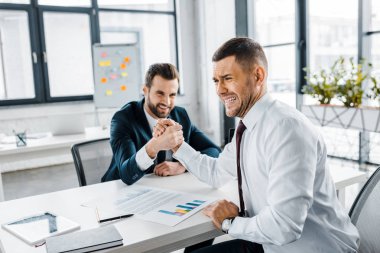İşadamları resmi içinde rakip bilek güreşi modern ofiste giymek. 