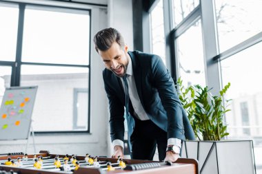 formal giyim masa futbolu oynayan sakallı işadamı heyecanlı 