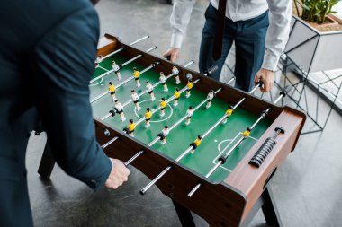 İşadamları görünümünü formal giyim masa futbolu oynayan kırpılmış 