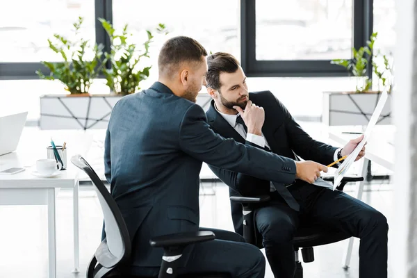 Hombre Negocios Señalando Papel Mano Compañero Trabajo Oficina Moderna —  Fotos de Stock