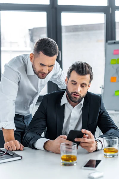 Hombres Negocios Guapos Mirando Teléfono Inteligente Oficina Moderna — Foto de Stock