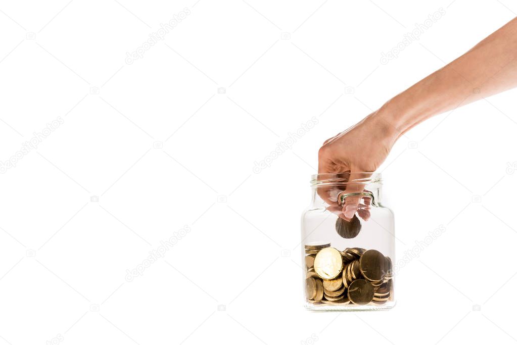 cropped view of woman putting golden coin in glass jar isolated on white 