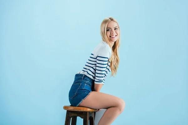 Neşeli Gülümseyen Kız Mavi Zemin Üzerine Ahşap Sandalye Poz — Stok fotoğraf