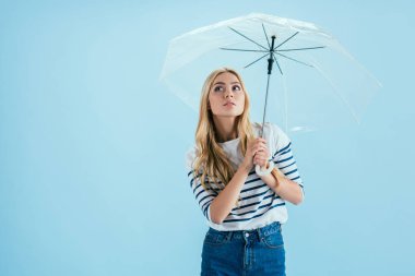Mavi arka plan üzerinde şemsiyesi altında poz şehvetli genç kadın