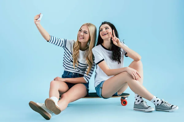 Meninas Elegantes Sentado Longboard Tomando Selfie Com Sinal Paz Fundo — Fotografia de Stock