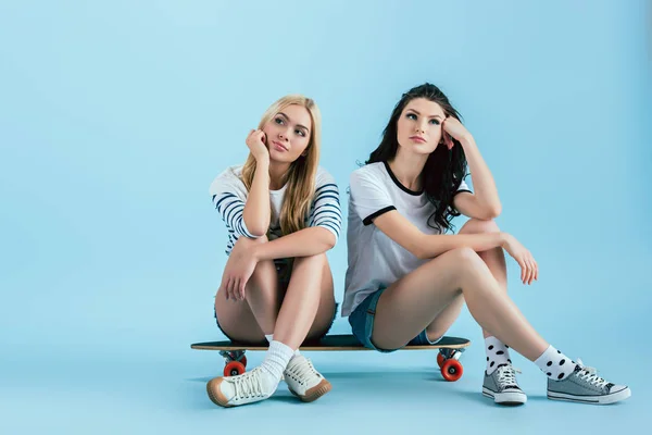 Meninas Pensativas Sentadas Longboard Apoiados Rostos Com Mãos Fundo Azul — Fotografia de Stock