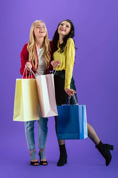 Fröhliche Mädchen Posieren Mit Bunten Einkaufstaschen Auf Lila Hintergrund — Stockfoto