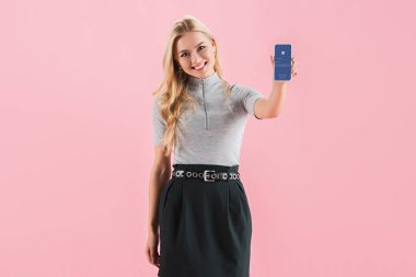 ekranında, pink izole Smartphone ile facebook app gösterilen neşeli sarışın kız
