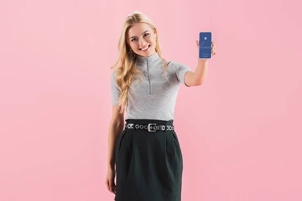 Vrolijke Blonde Meisje Smartphone Met Facebook App Tonen Het Scherm — Stockfoto