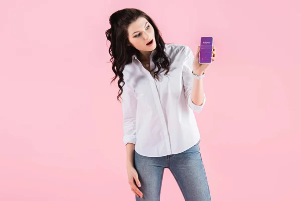 Zszokowana Dziewczyna Pokazuje Smartfona Aplikacji Instagram Ekranie Różowym Tle — Zdjęcie stockowe