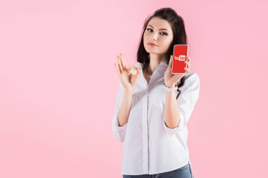 güzel esmer kız ok işareti ve youtube uygulaması ile akıllı telefon pink izole ekranda gösterilen