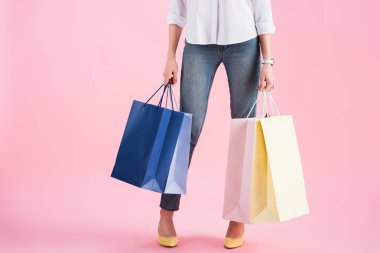 Kırpılan alışveriş torbaları, pink izole tutan kız görünümünü