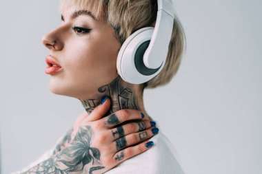 sarışın dövmeli kadın gri izole kulaklık müzik dinleme 