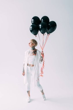 gri arka plan üzerinde siyah balon tutan dövmeler ile çekici sarışın kız 