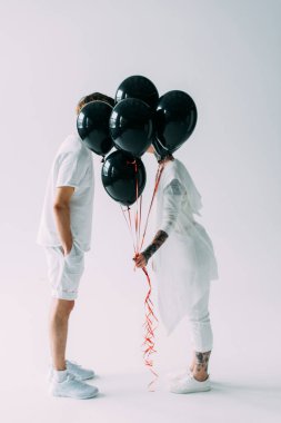 Erkek ve kadın üzerinde siyah balon gizleme arka plan gri 