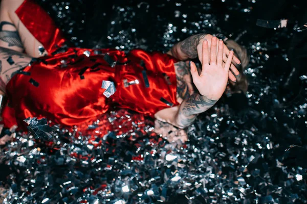 Drunk Woman Covering Face While Lying Floor Confetti Isolated Black — Stock Photo, Image