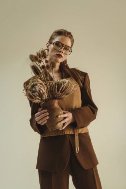 kil sürahisi ile buket üzerinde bej izole kuru tutarak vintage tarzı çekici moda kız