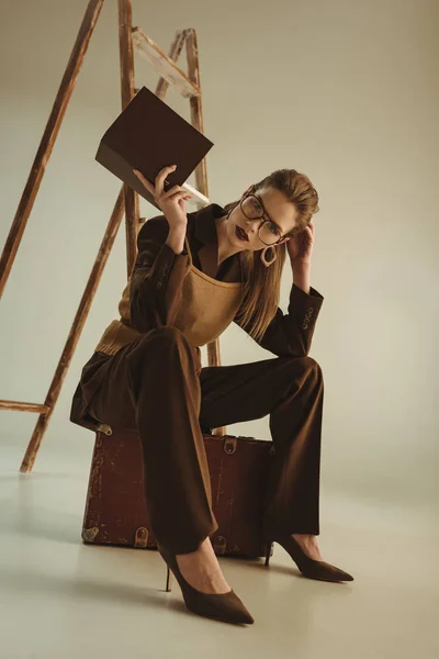 Όμορφο Κορίτσι Της Μόδας Κρατώντας Βιβλίο Και Κάθεται Κοντά Σκάλα — Φωτογραφία Αρχείου