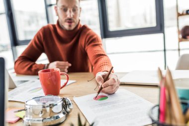 masada oturan ve loft Office belge üzerinde çalışan geçici iş adamı