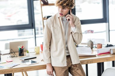 yakışıklı mimar planları loft Office tabloyla yakınındaki smartphone konuşurken