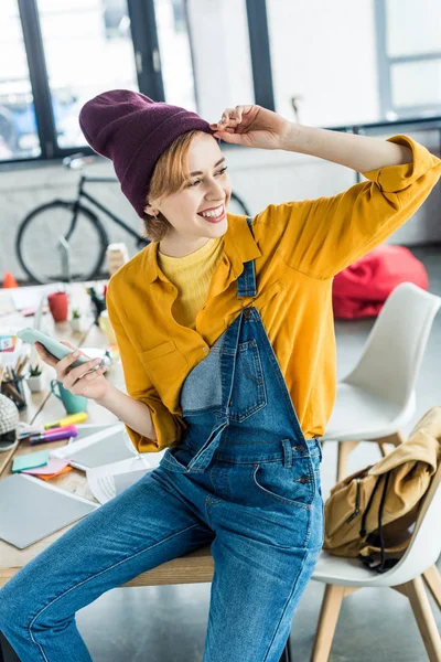 Hermosa Mujer Sonriente Diseñador Sentado Mesa Uso Teléfono Inteligente Oficina —  Fotos de Stock