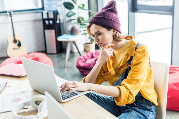 stressed young female it specialist using laptop in loft office 