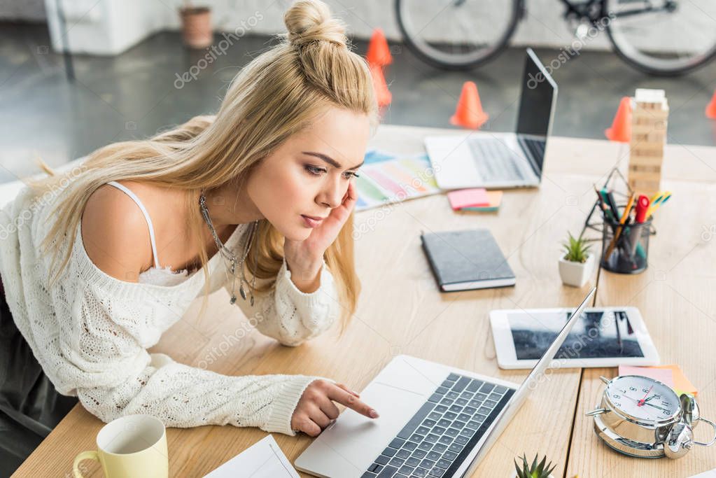 beautiful concentrated casual businesswoman working on laptop in loft office