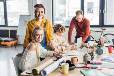 kadın ve erkek tasarımcıları ile dizüstü bilgisayarlar ve planları loft Office başlangıç proje üzerinde Grup