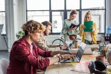 dizüstü bilgisayarlar ve dizüstü bilgisayarlar loft office ile başlangıç proje üzerinde kadın ve erkek rahat iş adamları