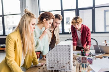 Grup birlikte loft Office Ev modeli üzerinde çalışan kadın ve erkek Mimarlar konsantre