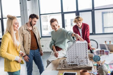 Grup birlikte loft Office Ev modeli üzerinde çalışan kadın ve erkek Mimarlar