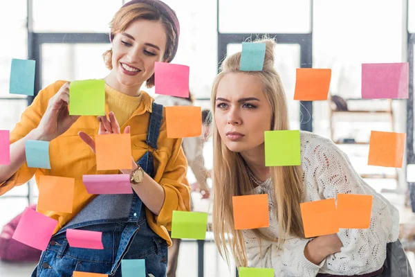 Beautiful Casual Businesswomen Looking Colorful Sticky Notes Glass Window Office — Stock Photo, Image