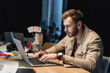 masada oturan ve dizüstü bilgisayar kullanma office yakışıklı rahat iş adamı
