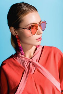 çekici şık kadın giyim moda yaşam mercan ve üzerinde izole mavi poz güneş gözlüğü
