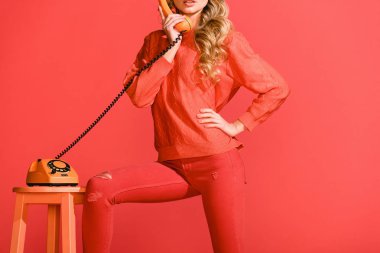 yaşam mercan izole retro döner telefon ile poz kız görünümünü kırpılmış. Yıl 2019 kavramının Pantone renk