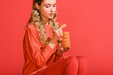 yaşam mercan izole macaroons tutan güzel kadın. Yıl 2019 kavramının Pantone renk