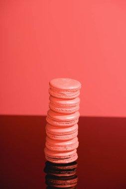 Yaşam mercan arka plan üzerinde tatlı macarons yığını. Yıl 2019 kavramının Pantone renk