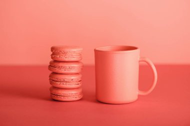 Kupası ve macaroons yaşam mercan renkli. Yıl 2019 kavramının Pantone renk