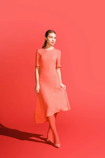 Chica Elegante Posando Vestido Coral Vivo Sobre Fondo Rojo — Foto de Stock