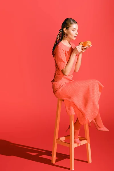 Mujer Moda Sosteniendo Plato Con Macarrones Coral Vivo Pantone Color — Foto de Stock