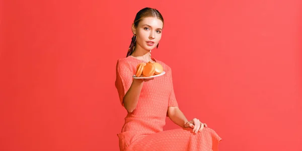 Aantrekkelijk Meisje Plaat Met Bitterkoekjes Geïsoleerd Levende Koraal Houden Pantone — Stockfoto