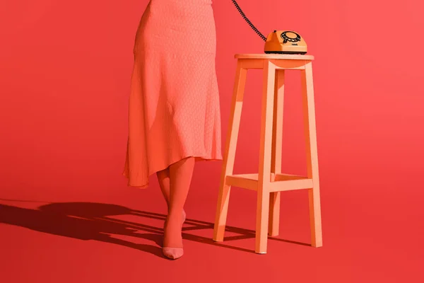 生きている珊瑚のスツールにレトロな回転式電話の女性の低断面図 2019 年概念の Pantone カラー — ストック写真