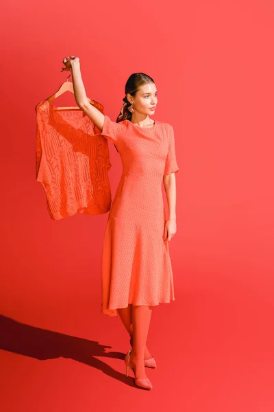 Mujer Moda Sosteniendo Percha Con Ropa Coral Vivo Pantone Color —  Fotos de Stock