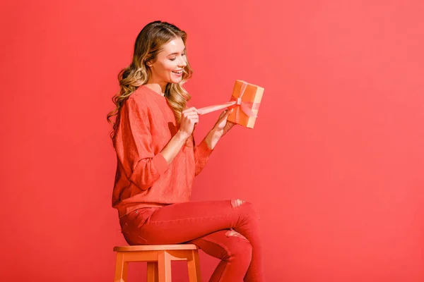 Happy Stylish Woman Holding Present Sitting Stool Isolated Living Coral — Stock Photo, Image