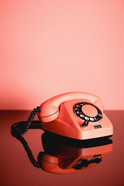 Living coral retro phone with copy space. Pantone color of the year 2019 concept