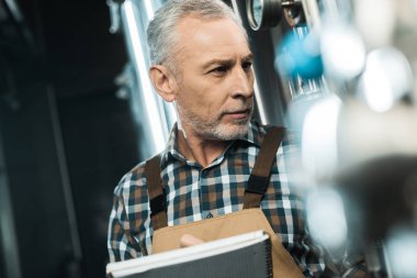 üst düzey brewer Not Defteri'nde bira ekipman incelenirken yazma