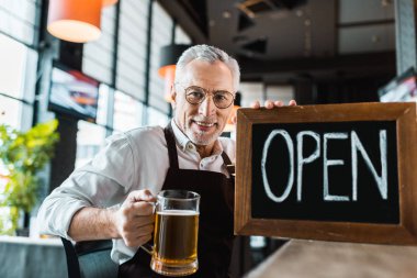 pub açık işareti ve bardak bira bar sayacı tutan kıdemli sahibi