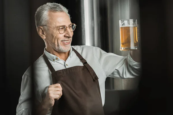 Sorrindo Cervejeiro Masculino Olhando Para Copo Cerveja Cervejaria — Fotografia de Stock