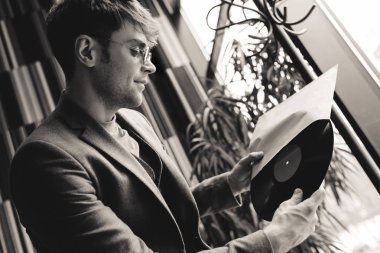 Vinil kaydı tutan eller, siyah ve beyaz fotoğrafçılıkta güneş gözlüklü adam 