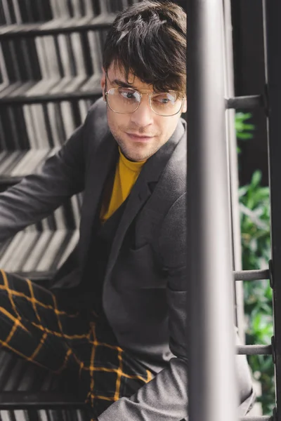 Verträumter Junger Mann Mit Brille Sitzt Auf Der Treppe — Stockfoto